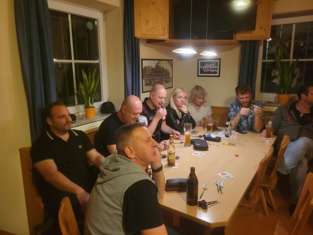 Eine gemütliche Runde von Teilnehmern des Turniers sitzen um den Tisch und genießen Ihre Getränke.