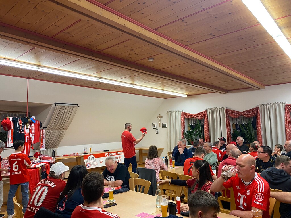 Ein FC Bayern Cappy wird vom !. Vorstand Michael verlost. Die Gäste blicken gespannt darauf wer den Preis wohl gewinnt.