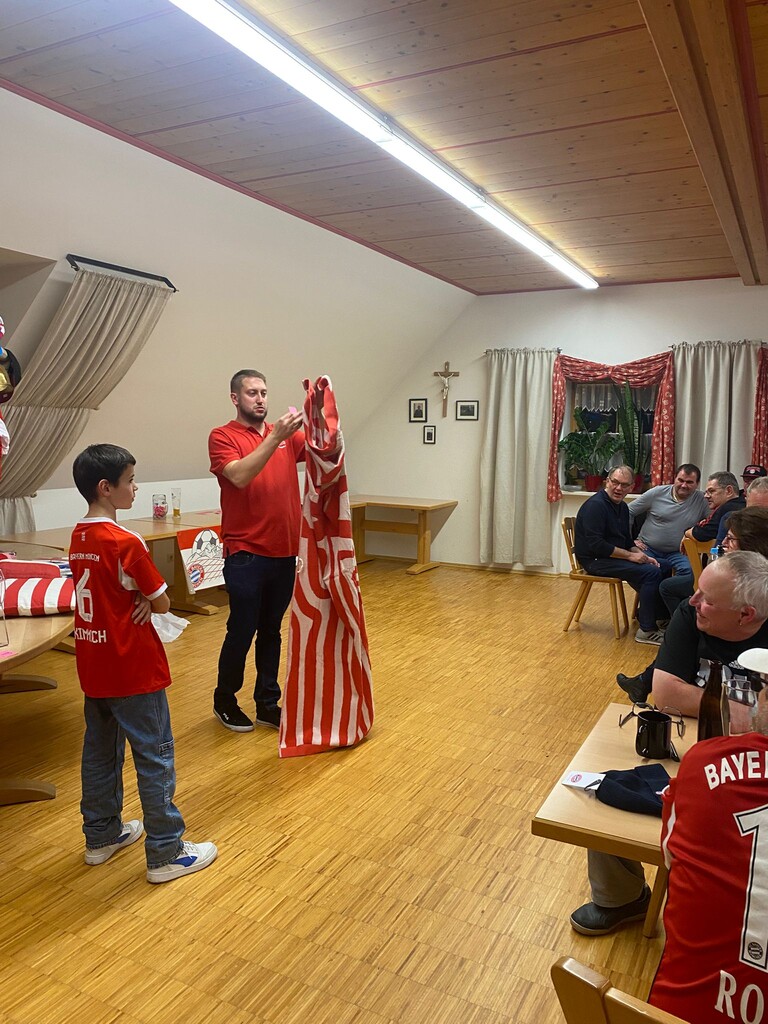 Der Vorstand verlost gerade ein großes Strandtuch vom FC Bayern.