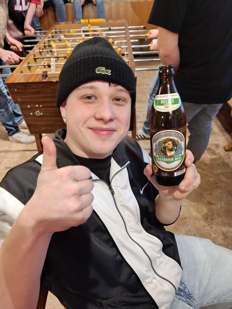 Ein Zuschauer genießt das Turnier mit einem Bier in der Hand.